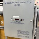 a grey rectangular object with buttons and a label