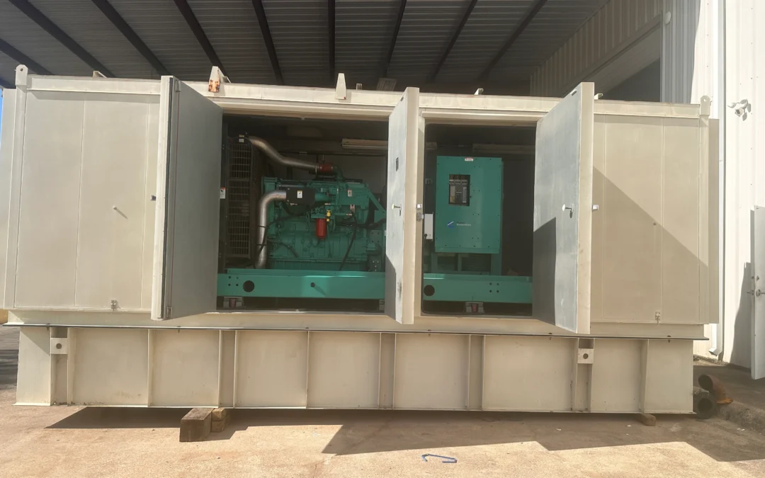 Industrial diesel generator set inside an outdoor metal enclosure with two large open doors, showing the green engine and control panel.