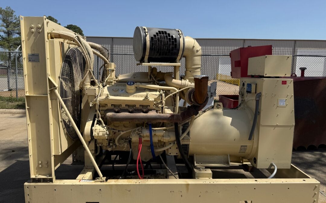 Large beige industrial generator set on a concrete skid outdoors, with a prominent cooling fan on the left.